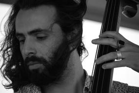 handsome young man plays double-bass, portrait