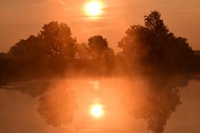 sunrise reflected in the water in the haze