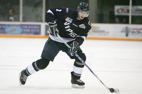 Hockey player in the black and white uniform on the ice arena