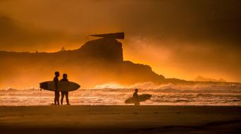 surfers on the beach during the surf