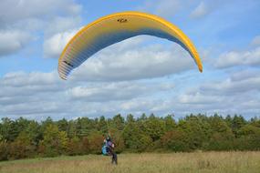 man with a paraglider landed on the field