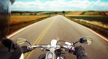 photo of motorcycle steering wheel and biker hands