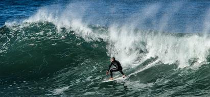 surfer rolls on a wave on the seashore