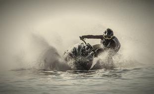 black and white photo of an athlete on a jet ski