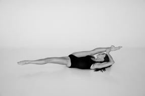 Gymnastics, young girl doing stretch exercise on floor