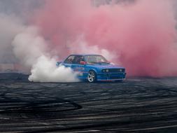 blue car speeding through colorful smoke