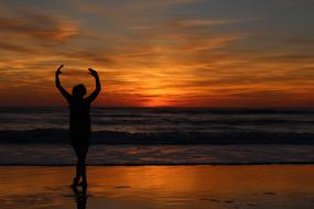 young girl Dancing on beach at Sunset