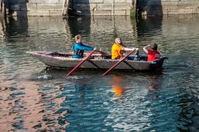 young people rowing on boat