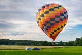 Hot Air Balloon over field at cloudy Sky