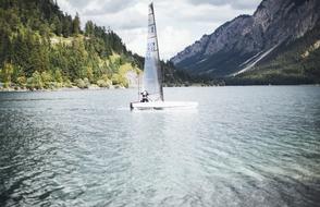 sailboat on the lake in the mountain valley
