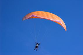 Gliding Paraglider in the blue sky