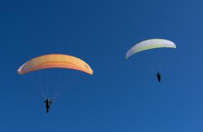 two skydivers in the blue sky on a sunny day