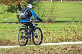 Cyclist, cycling on the bike on the path, among the colorful and beautiful fields