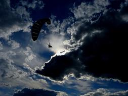 photo of a flying paratrooper against a stormy sky