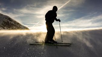 man Skiing on sparkling snow at sunset