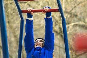 happy girl hanging on Horizontal bar outdoor