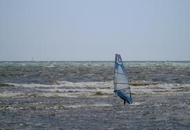 sailboat in waves on a sunny day