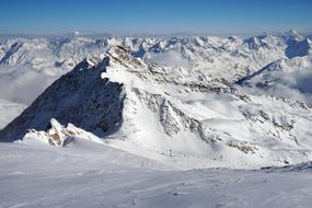 Beautiful landscape of the white, snowy mountains in light, at background with blue, gradient sky