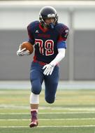 American football player in colorful uniform, with the ball, on the colorful field