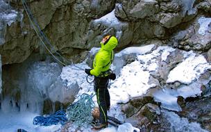 person with climbing ropes stands on rock looking up, italy, Serrai Di Sottoguda canyon