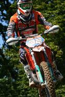 Person, on the colorful motorbike, in jump, among the green trees
