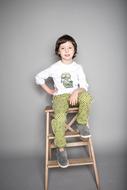 Cute child boy sits on ladder