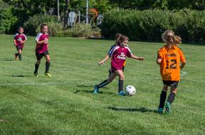 children play football in summer