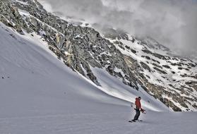 snowboarder is going down a snowy slope
