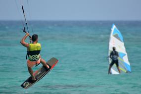 men windsurfing and kitesurfing by the ocean in Corralejo