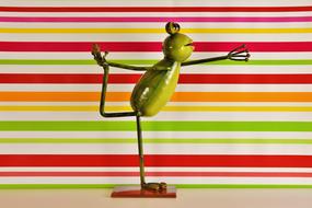 the frog is engaged in gymnastics against the background of colored lines