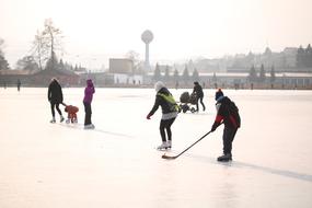 people play hockey on the pond in winter