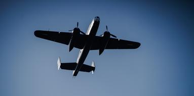 Low angle shot of the flying plane, in the beautiful, blue, gradient sky