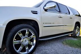 Side view of the white Cadillac Escalade car