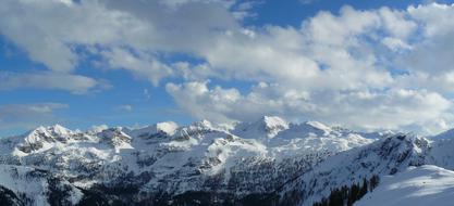 Beautiful, snowy Alpine mountains, under the blue sky with white clouds, in Zauchensee, Austria