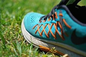 blue sports shoes on green grass close up