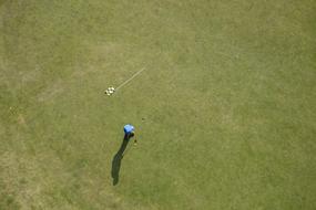 the athlete looks at the golf ball and the flag lies next to the hole