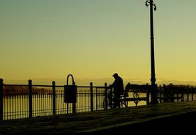 silhouette of a man on a bicycle on the promenade