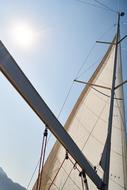 white sails on a boat against the blue sky
