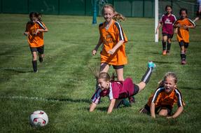 child girls play Soccer on lawn at Summer