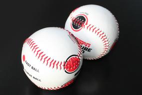 two red and white Baseball Balls at black background