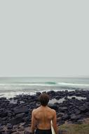 surfer on the coast, view from the back