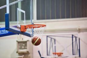 Colorful basketball in the white basketball net, of the orange hoop