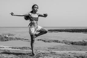 Black and white photo of the girl dancing on the beach