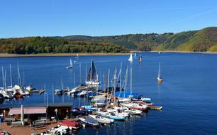 landscape of the sailboats near pier and lake