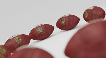 Colorful American football balls, on the white surface
