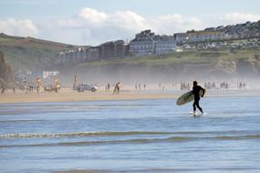 People on the beautiful Penhale Sands, with the colorful cliffs, in Cornwall, England, UK