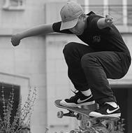 skateboarder jumping in black and white