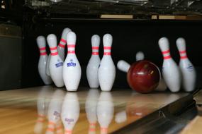 Colorful falling pink and red bowling ball on the wooden lane