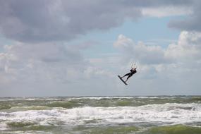 kitesurfing in high waves on a cloudy day