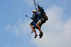 Paragliders taking off at blue sky background with white clouds in Normandy, France